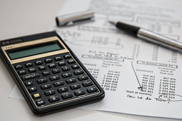 Close-up of financial documents with calculator and pen, ideal for business management themes.